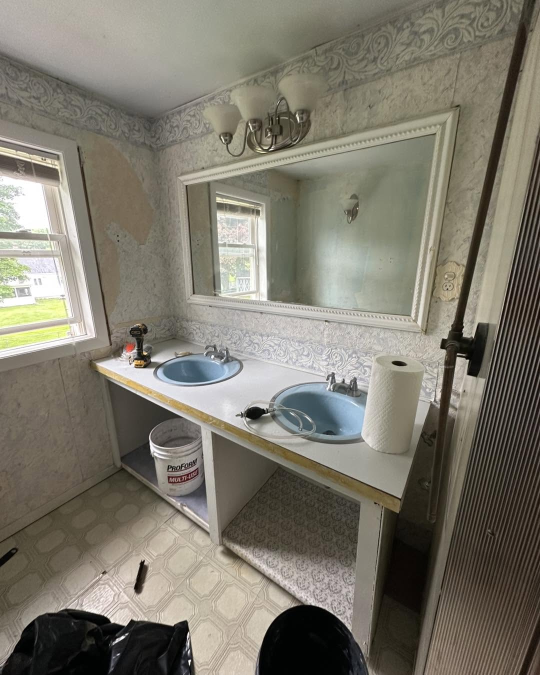 Bathroom before remodel — dated tub, worn vanity and finishes